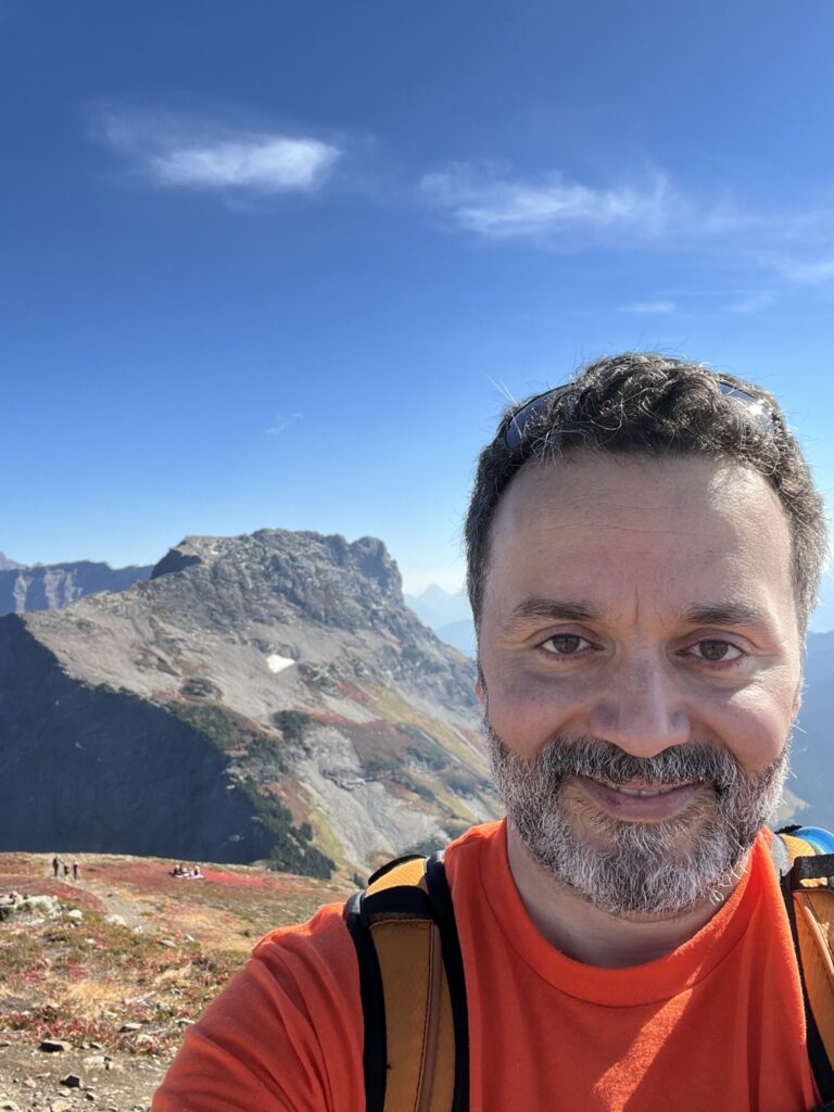 After a challenging hike, Jay resilience pays off with a beautiful mountain top view.